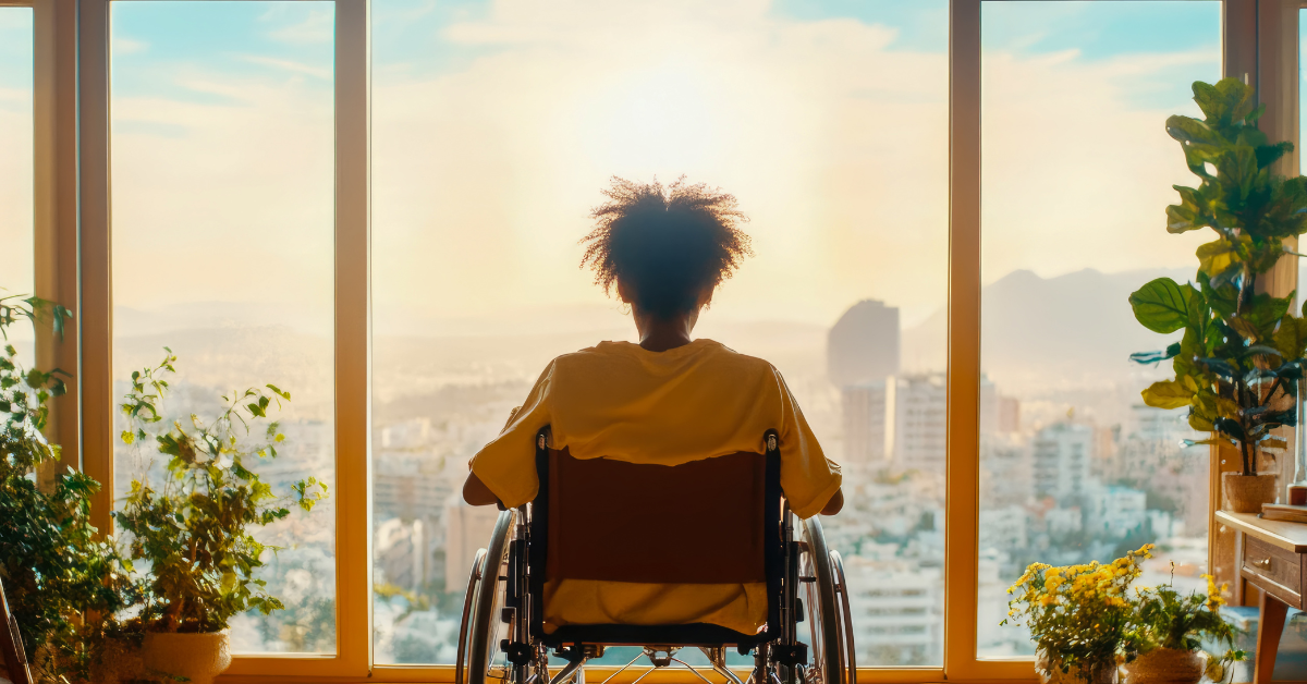 woman in wheelchair looking out a window